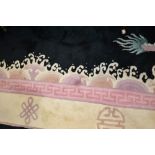 Chinese carpet with embossed floral design on a black ground with borders,