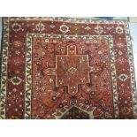 Karaja runner with repeating medallion design on a red ground with borders (damage to one corner),