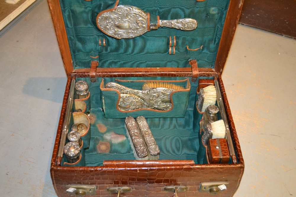 Late Victorian ladies embossed leather simulated crocodile skin dressing case containing silver