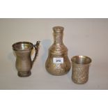 Middle Eastern white metal decanter and beaker with stopper together with a similar mug