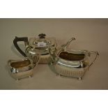 Edwardian silver three piece tea service of rectangular baluster half fluted design with bun feet,