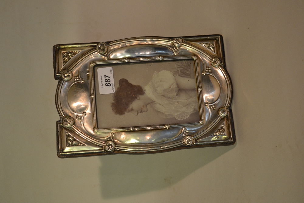 Birmingham silver photograph frame of an embossed stylised design on a wooden backing (slight
