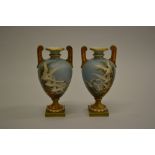 Pair of Royal Worcester baluster form two handled pedestal vases painted by Charles Baldwyn,