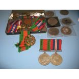 Two World War II medals with ribbons, a medal bar, R.A.F. badge, various buttons, crowns etc.