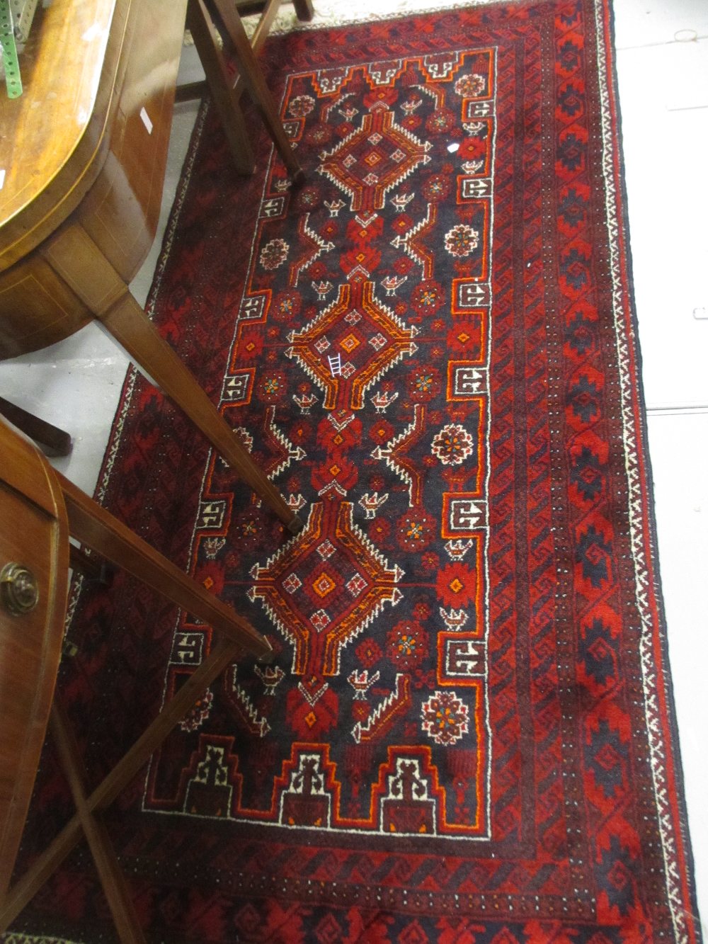 Belouch rug having repeating medallion design on a dark blue ground with multiple borders,