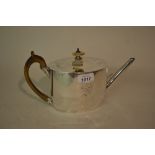 George III silver teapot of oval plain design engraved with a family crest and with carved