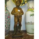 Goldscheider painted and gilded terracotta figure of a boy standing before a tree stump on a plinth