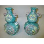 Pair of 20th Century Chinese pottery gourd shaped vases decorated in high relief with panels of