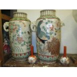 Pair of large Japanese two handled vases decorated with pheasants and flowers (both with cracks),