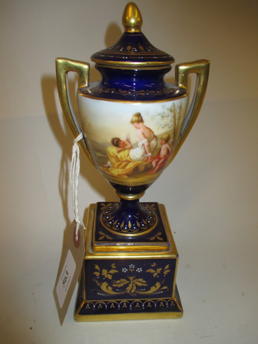 Vienna two handled urn shaped porcelain pedestal vase, painted with classical figures, signed Heer,