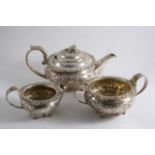 A GEORGE IV EMBOSSED THREE-PIECE TEA SET with floral borders & paw feet, initialled, by either