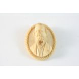 A VICTORIAN CARVED IVORY BROOCH of oval shape, depicting a bearded gentleman in formal dress, 5 x