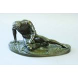 A BRONZE MODEL after the antique, of the Dying Gladiator, 14 1/2ins. (37cms.) wide
