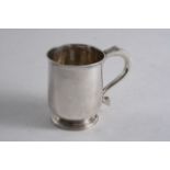 A SMALL GEORGE I MUG on a domed circular foot, with a scroll handle, by George Greenhill Jones,