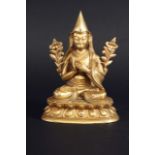 A GILT BRONZE SEATED BUDDHA the robes with engraved edges, 7 1/4ins .(18cms.) high