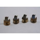 A SET OF FOUR SMALL, EARLY 20TH CENTURY NORWEGIAN SILVERGILT PLACE CARD HOLDERS each in the form