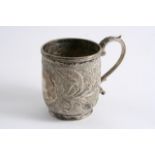 A MID 19TH CENTURY INDIAN COLONIAL MUG with a leaf-capped scroll handle, profusely chased with