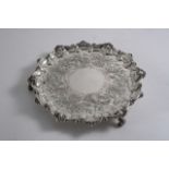 AN EARLY VICTORIAN ENGRAVED SALVER of shaped circular outline with a shell & scroll border &