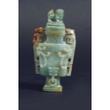 A JADE URN AND COVER of flattened baluster shape, the front carved in low relief with foliage,  5