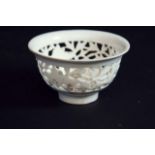 A BLANC DE CHINE CUP the body pierced with a band of foliage, 3 1/2ins. (9cms.) dia.