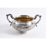 AN EARLY VICTORIAN CIRCULAR TWO-HANDLED SUGAR BOWL with floral scroll embossing & a gilt interior,