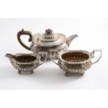 A LATE VICTORIAN THREE-PIECE TEA SET with part-fluted oval bodies, ball feet & borders of tongue &
