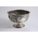 A LATE VICTORIAN EMBOSSED CIRCULAR ROSE BOWL on a domed foot, with two vacant cartouches, by J.