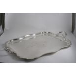 AN EDWARDIAN LARGE TWO-HANDLED TRAY of shaped oblong outline with a moulded, reeded border, the