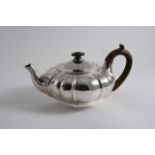AN EARLY VICTORIAN TEA POT of squat, melon-fluted form on a collet foot, engraved coat of arms, by