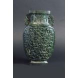 A SPINACH GREEN JADE VASE the flattened baluster body carved in low relief with flowering peony
