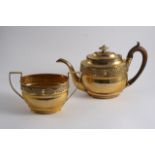 A GEORGE III GILT COPPER TEA POT & matching, two-handled sugar basin, each decorated in low relief