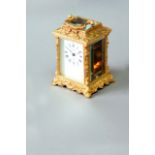 A CARRIAGE TIMEPIECE dial white enamel, signed Parkin, England, the ormolu case cast with putti