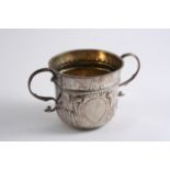 A QUEEN ANNE PORRINGER with twin S-scroll handles embossed swirl fluting around the lower body, a