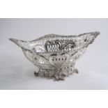 A LATE VICTORIAN PIERCED BASKET on an openwork foot, with an applied rim of flowers & scrolls, by