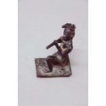 A BRONZE FIGURE of a kneeling native soldier with a gun, 4 1/2ins. (11cms.) high