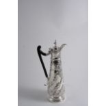 AN EDWARDIAN HOT WATER JUG OR EWER with an elongated, tapering body embossed with swirling