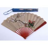 A CHINESE FAN Red lacquer guards carved with plant sprays, silk leaves painted with birds and