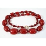 AN AMBROID BEAD NECKLACE formed with graduated oval-shaped beads, 72.5cm. long, 124 grams.
