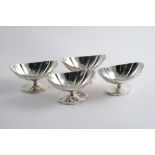 A SET OF FOUR GEORGE III PEDESTAL SALTS of shaped oval outline with reeded rims, by Joseph