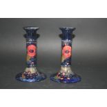 PAIR OF MOORCROFT CANDLESTICKS in the Pomegranate design, painted on a dark blue ground. Painted
