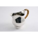 A CONTEMPORARY HANDMADE JUG with a cane-insulated handle & a collet foot, by Graham Watling (of