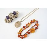 AN AMBER BEAD NECKLACE 51cm. long, 26 grams, a silver and carved amethyst bracelet and a gilt