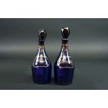 A PAIR OF BRISTOL BLUE SMALL DECANTERS with gilt labels for 'Brandy' and 'Rum', one stopper