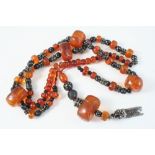 AN AMBER AND SILVER NECKLACE formed with graduated amber beads,  72cm. long.