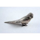 AN EDWARDIAN NOVELTY PEPPERETTE cast in the form of a budgerigar with glass eyes & a hinged base, by