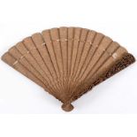 A CHINESE SANDALWOOD FAN The guards deeply carved with figures & buildings, carved & brise sticks;