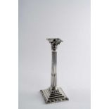 A GEORGE III CANDLESTICK with a fluted column, stepped square base & foliate capitol,