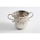 A CHARLES II WEST COUNTRY TWO-HANDLED CUP embossed around the upper body with floral scrolls,