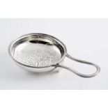 A GEORGE III LEMON STRAINER with a shallow circular bowl, a reeded rim & a single reeded handle,