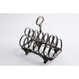 A VICTORIAN TOAST RACK oblong on four feet with seven bars, each formed by three joined rings,